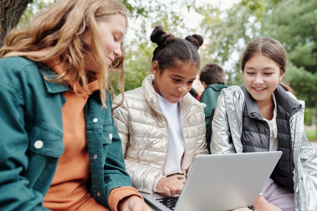 three girls learning French language in the park